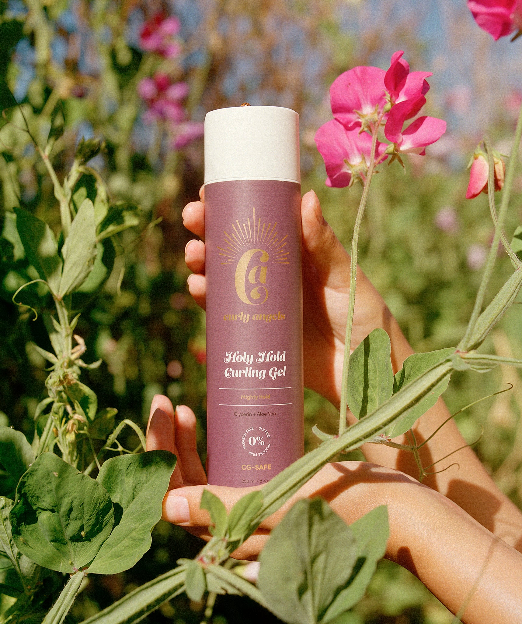 Curly Angels Holy Hold Curling Gel Cradled amongst sweat pea blossoms - gentle vegan styling gel, cruelty-free, silicone free, paraben-free curly-girl-method friendly