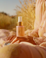 curly angels sacred scent fragrance  mist set resting on a hand mirror in a woman's lap, surrounded by golden wheat - vegan haircare, cruelty-free, suitable for all curl types