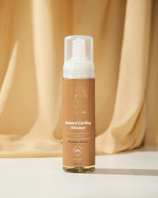 Curly Angels Sainted Curling Mousse, against golden draped fabric - vegan haircare, cruelty-free, suitable for all curl types