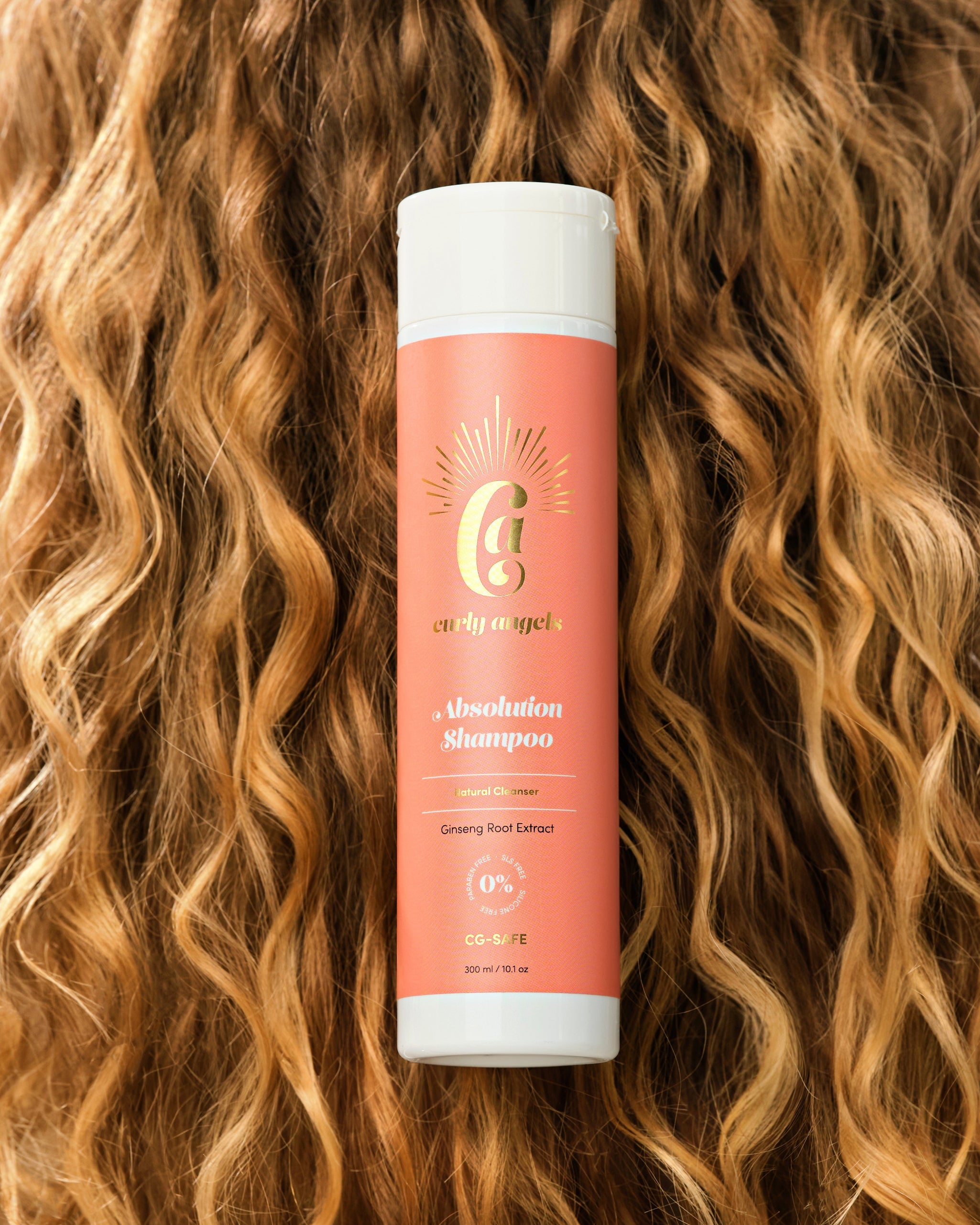 Curly Angels Absolution Shampoo, resting on curly red hair  - vegan haircare, cruelty-free